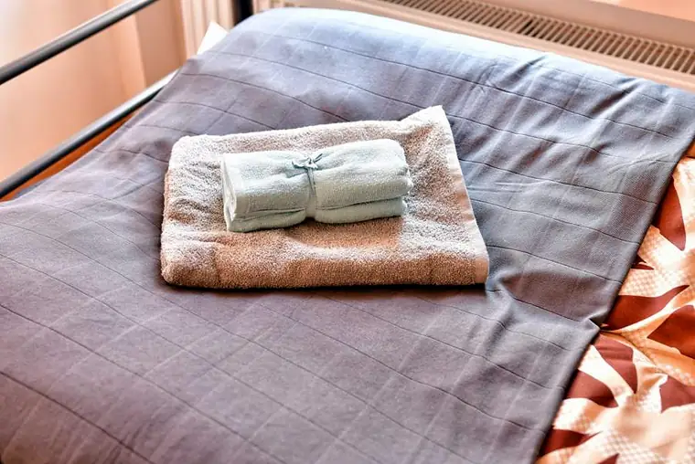 Złożone ręczniki na świeżo posłanym łóżku